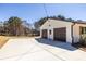 Detached two-car garage with a side entry door and an expansive concrete parking pad at 96 Sam Alexander Rd, Douglasville, GA 30134