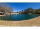 Scenic view of a serene pond with fountain feature, bordered by grassy banks and surrounding trees at 96 Sam Alexander Rd, Douglasville, GA 30134