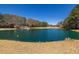 A picturesque pond featuring a small boathouse with serene water and surrounding trees at 96 Sam Alexander Rd, Douglasville, GA 30134