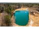 Aerial view of a clear, spring-fed pond featuring a fountain, and surrounded by wooded areas at 96 Sam Alexander Rd, Douglasville, GA 30134