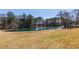 Scenic pond view surrounded by a spacious, grassy area and mature trees creating a peaceful, natural setting at 96 Sam Alexander Rd, Douglasville, GA 30134