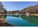 Beautiful view of a pond reflecting trees, a clear blue sky, and nearby buildings at 96 Sam Alexander Rd, Douglasville, GA 30134