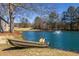 Charming pond scene featuring a small boat along the shore with fountain in the background, creating a peaceful setting at 96 Sam Alexander Rd, Douglasville, GA 30134