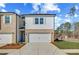 Two-story townhouse with white siding, brick facade, and attached single-car garage and landscaping at 300 Shine Dr, Stockbridge, GA 30281