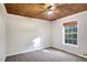 This bedroom features a natural wood plank ceiling and neutral wall color at 3337 Camens Way, Buford, GA 30519