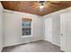 This bedroom features a natural wood plank ceiling and neutral wall color at 3337 Camens Way, Buford, GA 30519