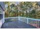 A grey painted wooden deck overlooks the wooded backyard, providing an inviting outdoor space at 3337 Camens Way, Buford, GA 30519