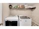 This laundry room includes modern appliances and storage shelf for optimal organization at 3337 Camens Way, Buford, GA 30519