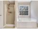 Bathroom with a separate shower, soaking tub, and large window at 3337 Camens Way, Buford, GA 30519