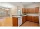 Well-lit kitchen with wood cabinets, neutral countertops, hardwood floor, and white appliances at 460 Tribble Gap Rd # 1004, Cumming, GA 30040