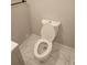Bathroom featuring a modern toilet with an open lid and marble look tile floors at 1956 Shirley Sw St, Atlanta, GA 30311