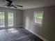 Bedroom with new dark floors, fan, and a pair of french doors that lead to the exterior at 1956 Shirley Sw St, Atlanta, GA 30311