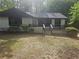 Charming one-story home with dark trim, a cozy front porch, and a lush, tree-filled yard at 1956 Shirley Sw St, Atlanta, GA 30311