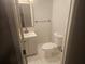 Modern powder room featuring a sleek vanity, round mirror, and marble-look tile flooring at 1956 Shirley Sw St, Atlanta, GA 30311