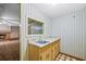 Convenient bar area adjacent to the living room features a sink, mirror, and storage cabinets at 3595 Limberlost Sw Trl, Stockbridge, GA 30281