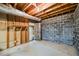Unfinished basement featuring block walls, exposed ceiling and duct work, and access to other parts of the home at 3595 Limberlost Sw Trl, Stockbridge, GA 30281