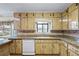 Functional kitchen featuring lots of cabinets and countertop space, with appliances, and a double sink under a window at 3595 Limberlost Sw Trl, Stockbridge, GA 30281