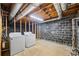 Unfinished laundry room with exposed ceiling, cinder block wall, and updated washer and dryer units at 3595 Limberlost Sw Trl, Stockbridge, GA 30281