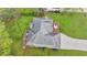Aerial view of a home with a paved driveway, two-car garage, deck with outdoor seating, and lush green lawn at 4995 Hyde Ct, Cumming, GA 30040