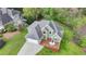 Aerial view of a house with a spacious driveway, garage, large deck, and well-manicured green lawn at 4995 Hyde Ct, Cumming, GA 30040