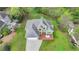 Overhead view of a home with a large deck, green lawn, mature trees, and a paved driveway leading to the garage at 4995 Hyde Ct, Cumming, GA 30040