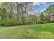 Expansive green backyard with a traditional wooden fence, mature trees, and flowering shrubs providing privacy and serenity at 4995 Hyde Ct, Cumming, GA 30040