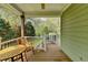 Cozy covered porch featuring a wooden table and chair, perfect for relaxing and enjoying the serene outdoor view at 4995 Hyde Ct, Cumming, GA 30040