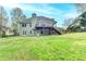 A rear exterior view of a home with a spacious backyard, deck, and lush greenery offering outdoor charm at 4995 Hyde Ct, Cumming, GA 30040