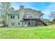 Rear exterior showcasing a two-story home with a deck, patio, and expansive yard offering outdoor enjoyment at 4995 Hyde Ct, Cumming, GA 30040