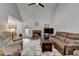 Comfortable living room featuring a stone fireplace, ceiling fan, and vaulted ceilings at 4995 Hyde Ct, Cumming, GA 30040