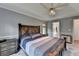 Comfortable main bedroom showcasing a wood bed frame, tray ceiling, and access to an ensuite bathroom at 4995 Hyde Ct, Cumming, GA 30040
