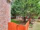 Backyard view with brick wall, wooden fence, mature trees, lawn and playset at 2570 Middleton Way, Grayson, GA 30017