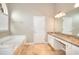 Bright bathroom features a soaking tub, a double sink vanity with granite countertop, and neutral-toned flooring at 2570 Middleton Way, Grayson, GA 30017
