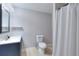 Cozy bathroom with a white toilet, navy vanity, and tiled floors at 2570 Middleton Way, Grayson, GA 30017