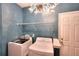 Modern laundry room featuring a chandelier, painted blue walls and updated appliances at 2570 Middleton Way, Grayson, GA 30017