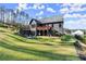 Spacious backyard with lush green grass, mature trees, and a stylish deck and patio area for relaxation and entertainment at 4835 Fields Bridge Rd, Cumming, GA 30028
