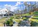 The backyard featuring tiered landscaping, a manicured lawn, and beautiful trees at 4835 Fields Bridge Rd, Cumming, GA 30028