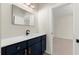 Bathroom featuring navy blue vanity with white countertop, large mirror, and an entrance to another room at 4835 Fields Bridge Rd, Cumming, GA 30028