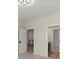 Hallway featuring neutral walls, white doors, and an open view to a staircase at 4835 Fields Bridge Rd, Cumming, GA 30028