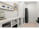 Convenient laundry room with stackable washer/dryer, storage cabinets, and decorative wall art at 4835 Fields Bridge Rd, Cumming, GA 30028
