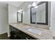 Bathroom featuring double sinks, granite countertops, dark cabinets, and framed mirrors at 6351 Wedgeview Ct, Tucker, GA 30084