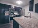 Granite counters, stainless appliances, and dark wood cabinets are the focal point of this kitchen at 6351 Wedgeview Ct, Tucker, GA 30084