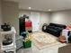 Finished basement area featuring a playspace and black leather sofa at 9030 Brockham Way, Johns Creek, GA 30022