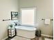 Bright bathroom featuring modern tub, window, and neutral paint at 9030 Brockham Way, Johns Creek, GA 30022