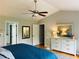 Bedroom featuring ceiling fan, large dresser, and open doorways to other rooms at 9030 Brockham Way, Johns Creek, GA 30022