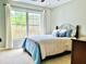 Cozy bedroom featuring a large window with natural light, a ceiling fan, and comfortable bed at 9030 Brockham Way, Johns Creek, GA 30022