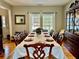 Traditional dining room features a large table set for a formal dinner and hardwood flooring at 9030 Brockham Way, Johns Creek, GA 30022