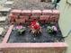 Landscaped flower bed featuring pink and red blooms, bordered by red brick edging at 9030 Brockham Way, Johns Creek, GA 30022