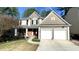 Charming two-story home with a two-car garage, manicured lawn, and red front door at 9030 Brockham Way, Johns Creek, GA 30022