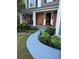Inviting home exterior featuring a brick facade, covered porch, and a beautifully landscaped walkway leading to the front door at 9030 Brockham Way, Johns Creek, GA 30022